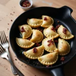 A plate of golden, pan-fried gluten free pierogi garnished with fresh herbs and served with a side of creamy sour cream on a rustic wooden table.